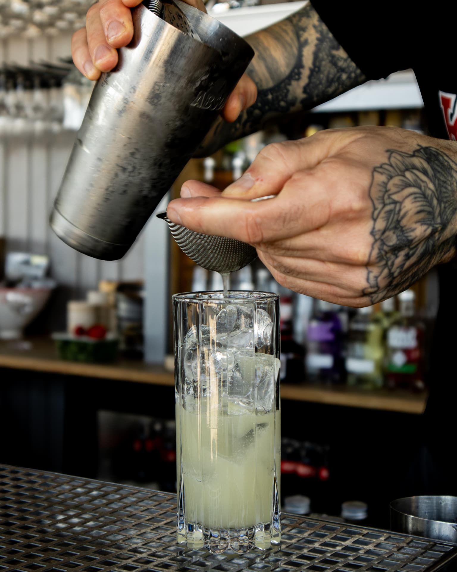 Bartender häller upp en cocktail